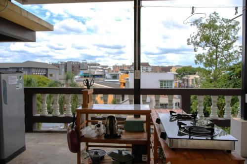 a balcony with a stove and a view of a city at October Hostel ChiangMai in Chiang Mai