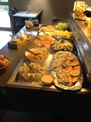 a buffet line with many different types of food at Brit Hotel Baillet-en-France in Baillet-en-France