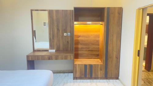 a mirror on a wall next to a bed in a room at أجنحة السلام للشقق المفروشة in Al Madinah