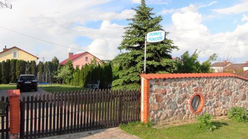 a street sign on top of a brick fence at Pokoje Żabi Staw in Mikołajki