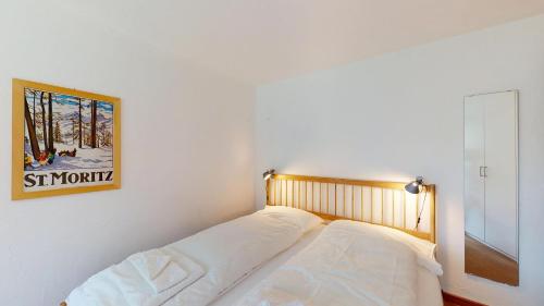 a bed in a room with a picture on the wall at Abitaziun Quadratscha 20 - Samedan in Samedan
