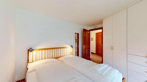 a bedroom with a bed with white sheets at Abitaziun Quadratscha 20 - Samedan in Samedan