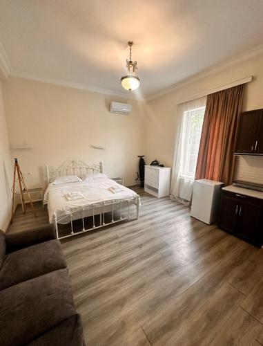 a bedroom with a bed and a couch in a room at villa gardens in K'obulet'i