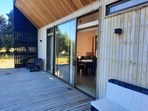 a house with a deck with a bench and a table at Casa en San Andres Futrono in Futrono