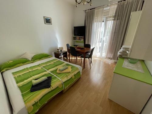 a bedroom with a bed and a desk and a table at Apartments Villa More in Makarska