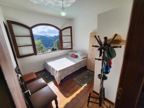 a bedroom with a bed and a large window at #Hospedagem Nota 10 de Teresópolis in Teresópolis