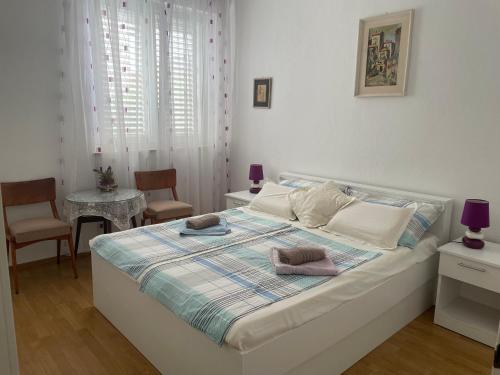 a bedroom with a bed with two chairs and a table at Apartments Villa More in Makarska