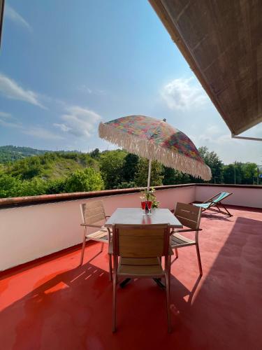 a table and chairs on a balcony with an umbrella at Denise B&B 
