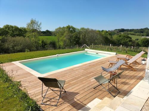 a swimming pool with chairs and a wooden deck at Maison basque de charme avec piscine in Souraïde