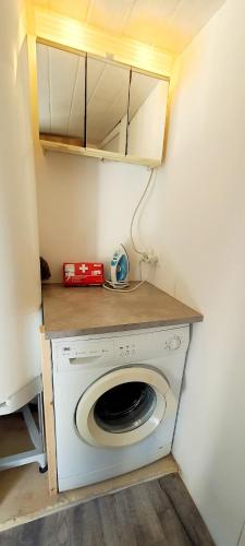 a washing machine in a room with a counter at Le gros chêne, gite du XVIII siècle, jacuzzi privatif in Carsac-Aillac