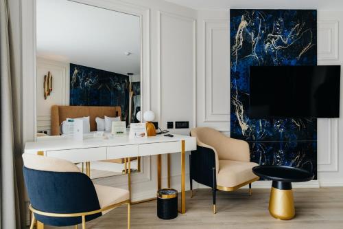 a living room with a desk and chairs and a tv at Qlusive Hotel in Kusadası