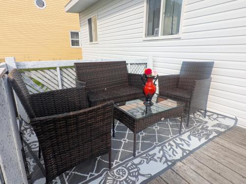 une terrasse avec 2 chaises et une table avec un vase dans l'établissement 102 Two Single Bed Bedroom Downtown Glace Bay, à Glace Bay