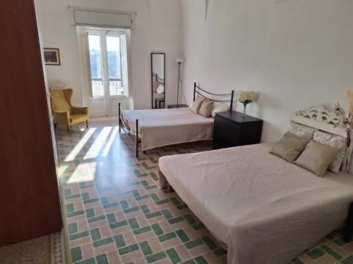 ein Schlafzimmer mit 2 Betten und einem Stuhl darin in der Unterkunft Casa vacanze San Martino in Irsina