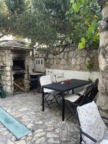 a black table and chairs and a stone fireplace at Apartments Villa More in Makarska
