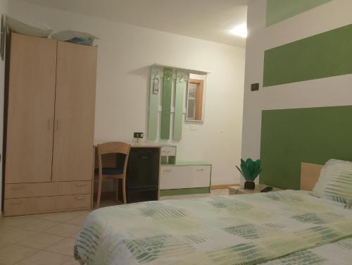 a bedroom with a bed and a desk and a kitchen at Bed and Breakfast Galet in Ledro