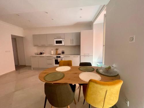 a kitchen and dining room with a wooden table and chairs at Appartement T3 Place du Marché in Bastia