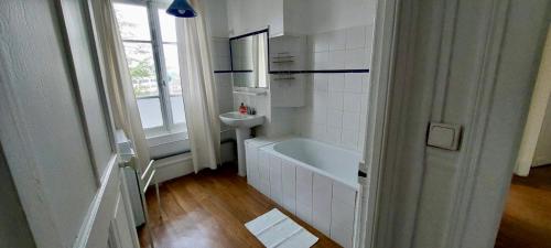 une salle de bain blanche avec une baignoire et un lavabo dans l'établissement 3 chambres - 4 couchages, à Châlons-en-Champagne