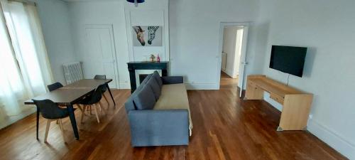 un salon avec un canapé et une table dans l'établissement 3 chambres - 4 couchages, à Châlons-en-Champagne