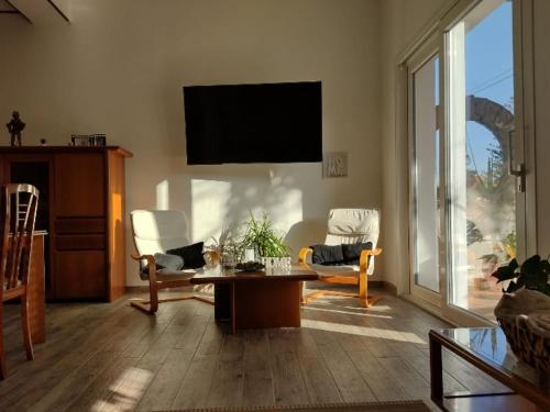 a living room with a tv and a table and chairs at Il Ginepro del Campidano in Nuraminis