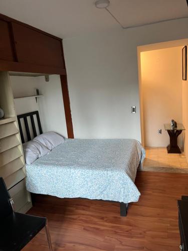 a bedroom with a bed with a blue comforter at Pequeña París Coyoacán, Habitación Privada WiFi in Mexico City