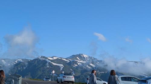 a group of people standing in front of a mountain at House in forest in Gomi