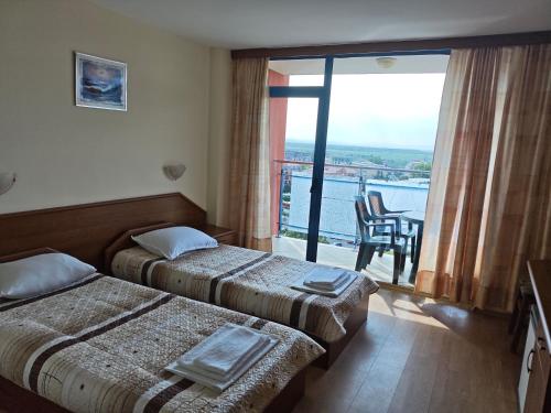 a hotel room with two beds and a balcony at Hotel Shipka Beach in Sunny Beach