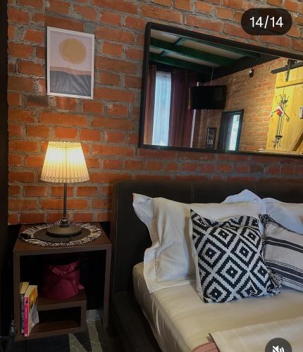 a bedroom with a bed with a lamp and a brick wall at Smestaj sa bazenom Sunny Hill in Smederevska Palanka
