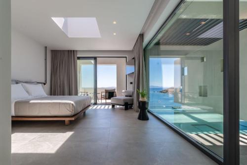 a bedroom with a bed and a swimming pool at Orion Tinos Suites in Vrachonisída Chántra