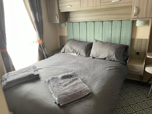 a bed with a towel on it in a bedroom at Tingdene caravan park north dene in Lowestoft