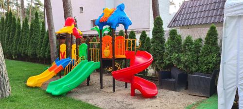 a playground with a slide in a yard at Villa Tropico śniadanie i obiadokolacja in Pobierowo