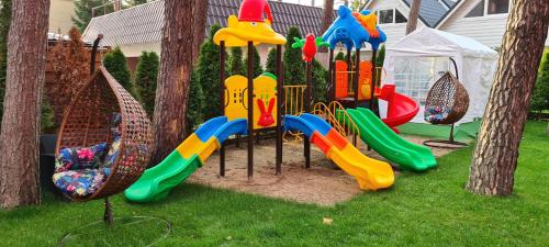 a playground with a slide in the grass at Villa Tropico śniadanie i obiadokolacja in Pobierowo
