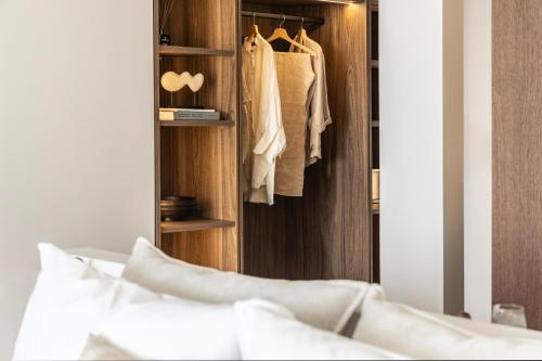a bedroom with a closet with white clothes at Orion Tinos Suites in Vrachonisída Chántra