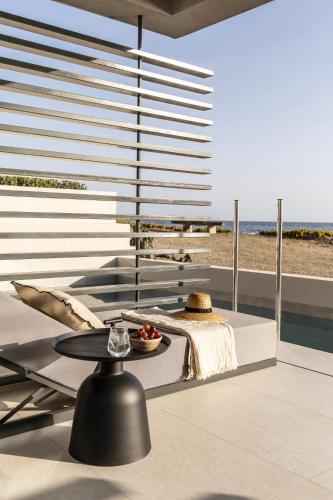 a living room with a table and a view of the beach at Orion Tinos Suites in Vrachonisída Chántra