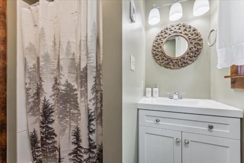 Un baño con lavabo y cortina de ducha. en Dragonfly Cove - Nature-inspired Lakeside Living, en Tobermory