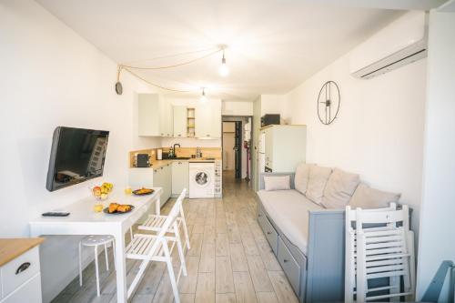 une cuisine et un salon avec un canapé et une table dans l'établissement Climatisation-5 min plage -Terrasse-AH, à Leucate-Plage