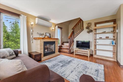 a living room with a couch and a fireplace at Dragonfly Cove - Nature-Inspired Lakeside Living in Tobermory