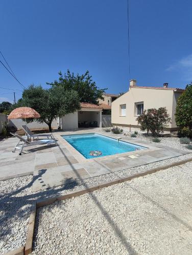 - une piscine avec une chaise et un parasol dans l'établissement Maison Cardelines avec piscine privée, à Morières-lès-Avignon