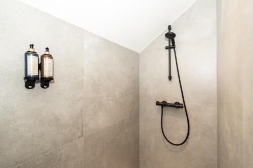 a shower in a bathroom with two bottles on the wall at Hôtel de la Poste in Gedinne