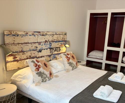 a bedroom with a bed with two pillows on it at Pé na Areia, Alojamento Local in Porto Covo