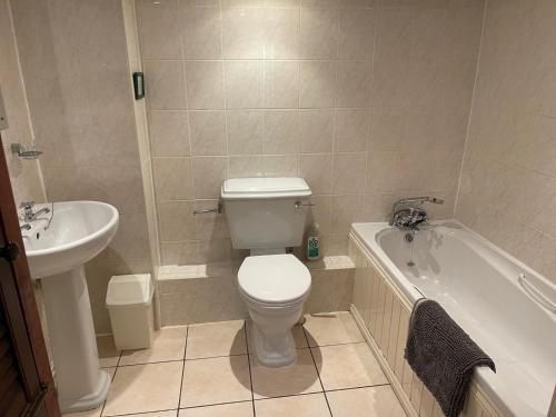 ein Badezimmer mit Toilette, Waschbecken und Badewanne in der Unterkunft South Sandpark Cottage in Barnstaple
