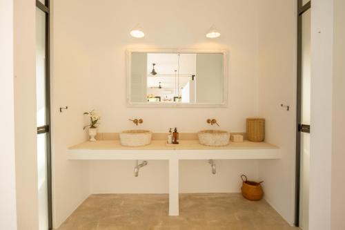 a bathroom with two sinks and a mirror at Thea Estate in Kritou Terra