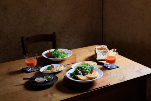 - une table en bois avec des bols de nourriture et de boissons dans l'établissement Private Forest Cottage for Two, Organic Lifestyle, à Bungoono