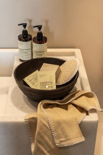 a table with three bottles of soap in a bowl at Orion Tinos Suites in Vrachonisída Chántra