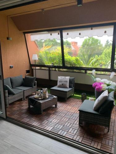a living room with couches and tables and a large window at Bilocale nuovo - Basiglio Humanitas in Basiglio