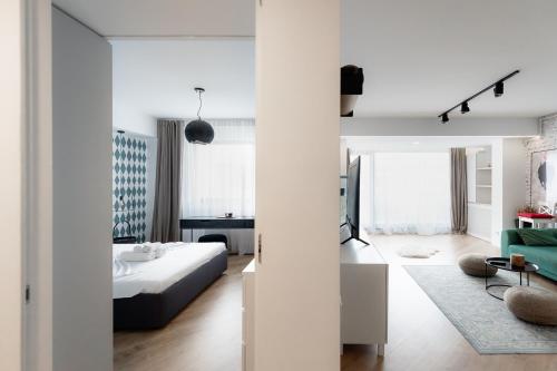 a white bedroom with a bed and a living room at City One I One Bedroom Apartment near Pipera Plaza Mall in Voluntari