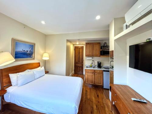 a bedroom with a white bed and a kitchen at Copley House in Boston