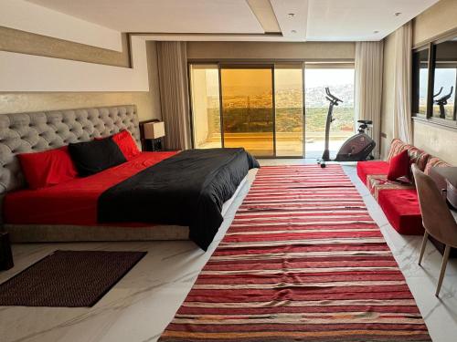 a bedroom with a red bed and a large rug at Tayyurt Surf Camp Tamraght Aourir in Awrir