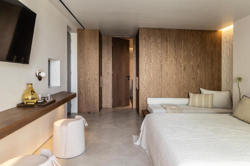 a hotel room with two beds and a television at Orion Tinos Suites in Vrachonisída Chántra