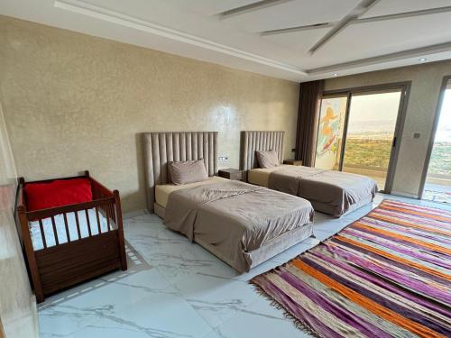 a hotel room with two beds and a rug at Tayyurt Surf Camp Tamraght Aourir in Awrir