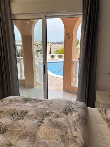a bedroom with a bed and a view of a pool at Casa Kiga in Ciudad Quesada
